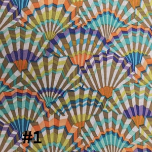 Puede incluir: Una tela con un patrón repetitivo de abanicos coloridos. Los abanicos están hechos de rayas de color naranja, azul, verde y morado. El fondo es de color marrón claro. La tela tiene el número #1 impreso en ella.