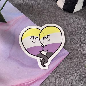 Calcomanía de vinilo mate con la bandera del orgullo LGBTQIA+ y fantasmas no binarios abrazados