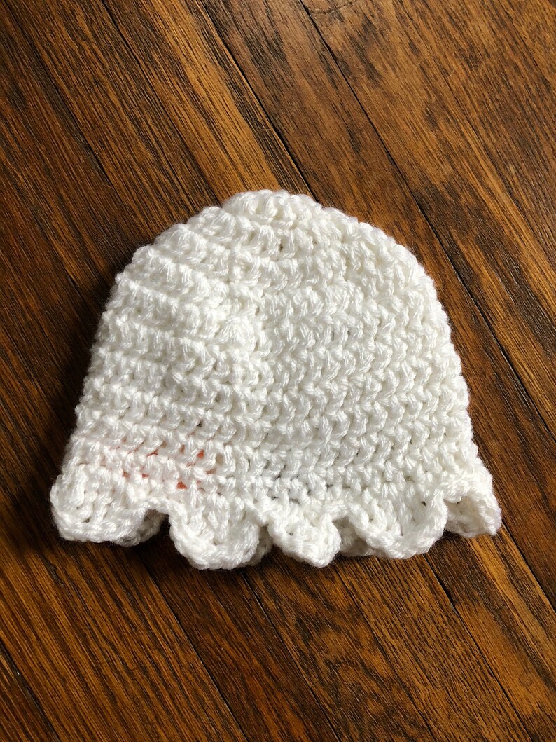May include: White crocheted hat with a scalloped edge.