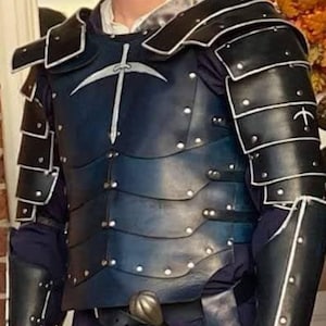 May include: A dark blue and black leather armour set. The chest piece features a silver emblem and is riveted with silver studs. The shoulders and arms are protected by layered black plates. The armour is designed for protection and cosplay.