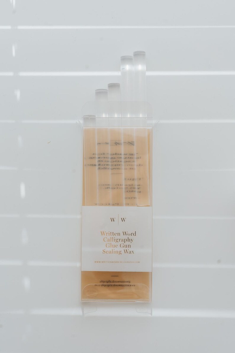 A pack of sealing wax sticks for a glue gun. The clear packaging has a white label with the text "Written Word Calligraphy Glue Gun Sealing Wax." The wax sticks are a clear.