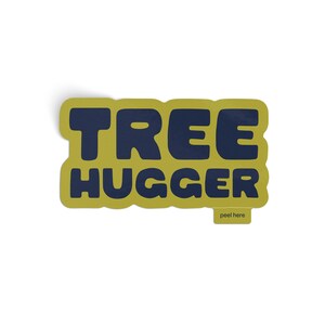 Vinyl sticker that says 'tree hugger' in all caps chunky dark navy blue font with green background and a peel here tab on white background.