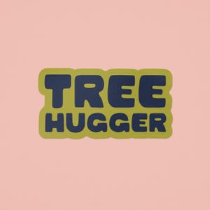 Vinyl sticker that says 'tree hugger' in all caps chunky dark navy blue font with green background and a peel here tab on pink background.