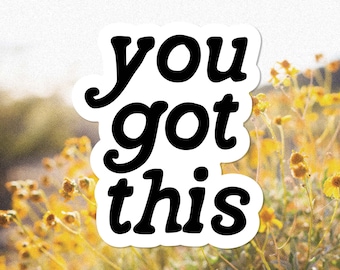 May include: A white sticker with black text that reads "you got this" against a blurry background of yellow flowers.