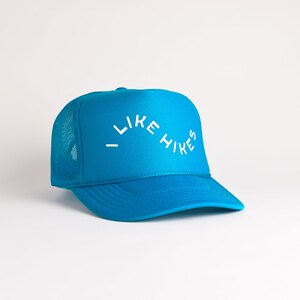May include: A blue trucker hat with a white mesh back and the text "I LIKE HIKES" in white.