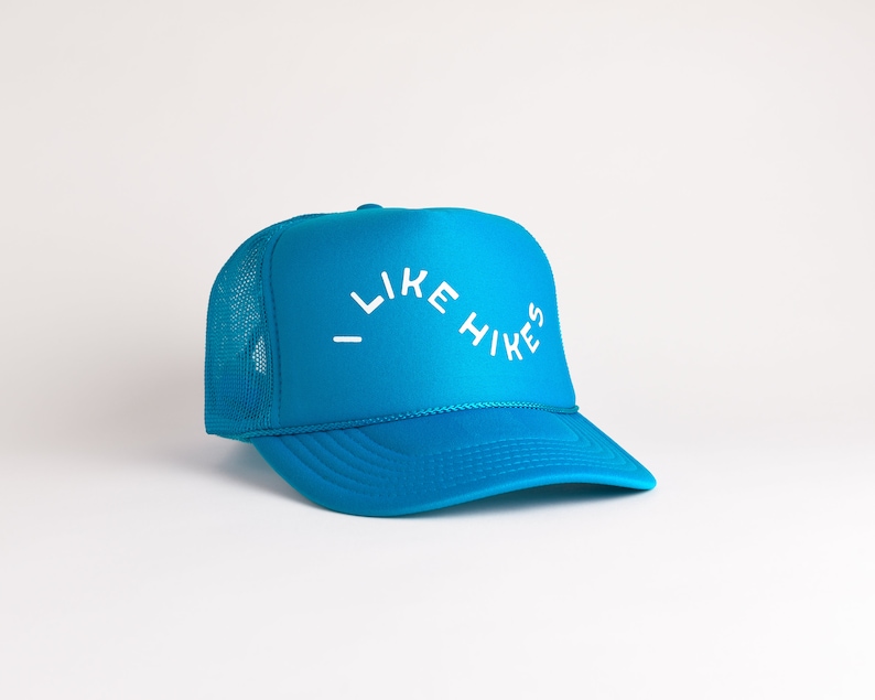 May include: A blue trucker hat with a white mesh back and the text "I LIKE HIKES" in white.