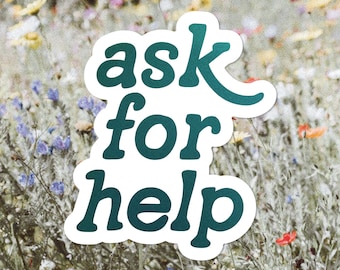 May include: A white sticker with the words "ask for help" in teal script. The sticker is set against a blurred background of wildflowers in various colors, including yellow, purple, and red.