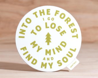May include: A round white sticker with the text "Into the forest I go to lose my mind and find my soul" in a green font. A green tree graphic is in the center. The sticker has a small "peel here" tab.