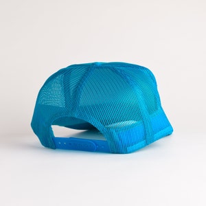 May include: A bright blue mesh trucker hat with a plastic adjustable strap.