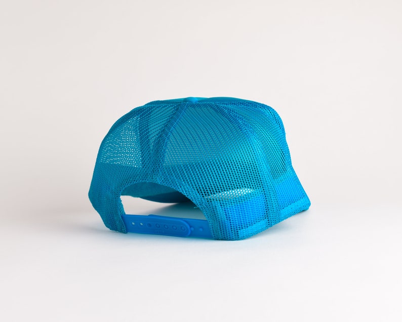 May include: A bright blue mesh trucker hat with a plastic adjustable strap.
