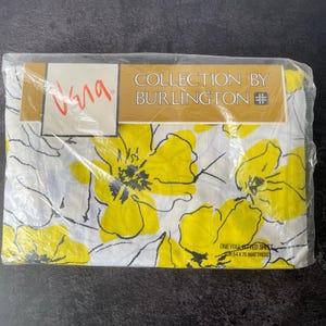 May include: A packaged full fitted sheet by Burlington with a white background and a yellow floral pattern featuring black line art outlines. The packaging includes the text Collection by Burlington and One Full Fitted Sheet for 54 x 75 mattress.