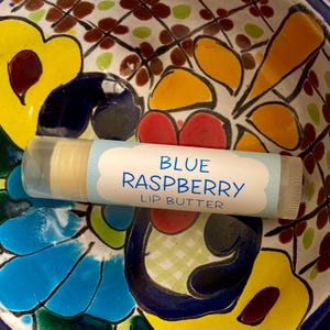 May include: A blue and white lip balm tube with the text "BLUE RASPBERRY LIP BUTTER" on the label.