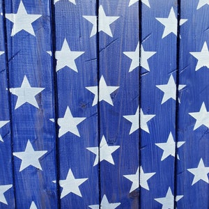 Puede incluir: Una superficie de madera azul con un patr&oacute;n de estrellas blancas pintadas sobre ella. Las estrellas est&aacute;n espaciadas uniformemente y crean un patr&oacute;n repetitivo.