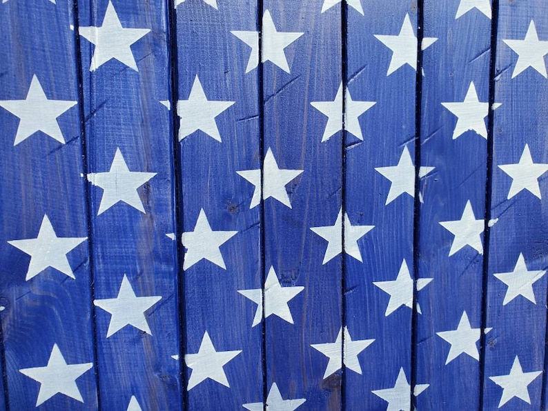 Puede incluir: Una superficie de madera azul con un patr&oacute;n de estrellas blancas pintadas sobre ella. Las estrellas est&aacute;n espaciadas uniformemente y crean un patr&oacute;n repetitivo.