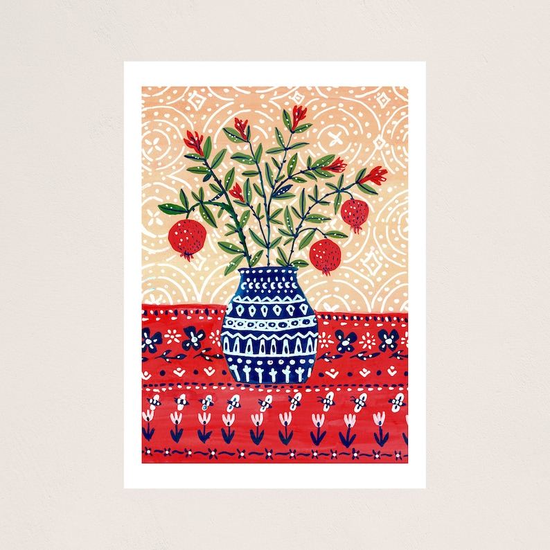Może przedstawiać: Niebieski i biały waz z bukietem czerwonych kwiat&oacute;w granatu na czerwono-białym obrusie.