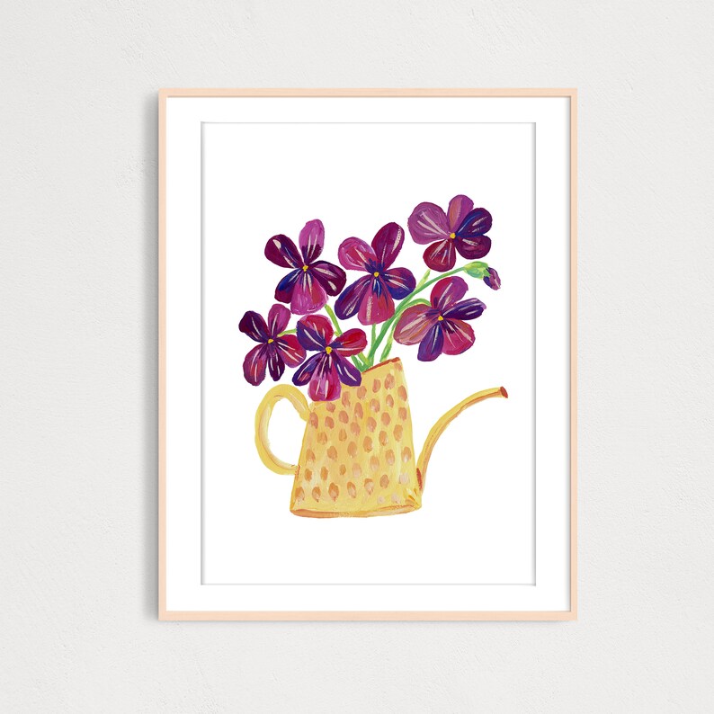 Puede incluir: Una regadera amarilla con estampado de lunares llena de un ramo de flores moradas.