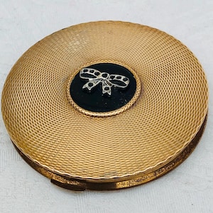 1950s Gold-Tone & Black Enamel Powder Compact With A Silver Metal Bow Detail.