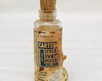 Antyczna zakorkowana szklana butelka farmaceutyczna „Carters Little Liver Pills” zawierająca oryginalne tabletki z oleju z wątroby dorsza.