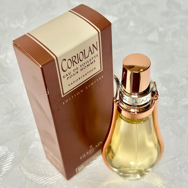 May include: A bottle of Guerlain Coriolan Eau de Toilette Pour Homme, a limited edition fragrance. The bottle is a unique shape with a gold-colored cap and accents. The box is brown with the fragrance name and details.