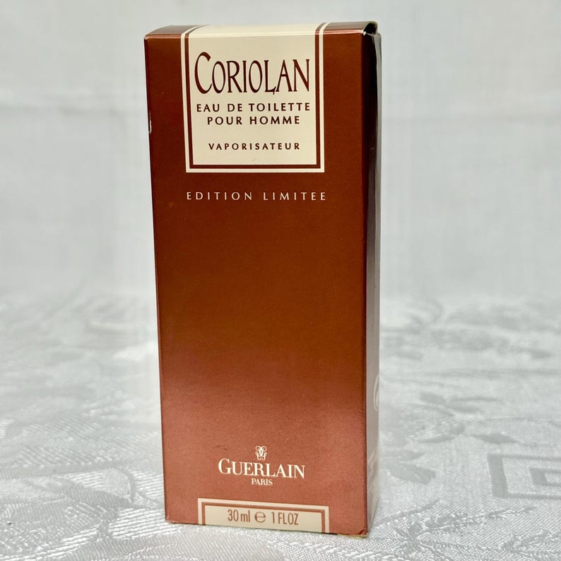 May include: A brown rectangular box of Coriolan Eau de Toilette Pour Homme. The box has a white label with the product name and details. The bottom of the box reads "30ml e 1 FL OZ". The brand name "Guerlain Paris" is also visible.