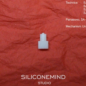 May include: A small, white plastic mechanism unit, MR3A, for a Panasonic SA-PM35MD, against a textured red background. The image includes the text "Technics" and model numbers, and "SILICONEMIND STUDIO".