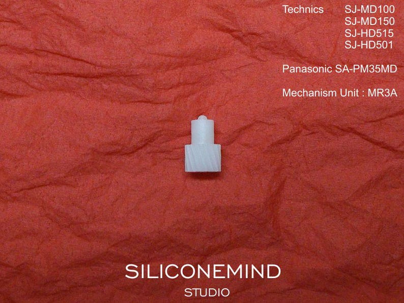 May include: A small, white plastic mechanism unit, MR3A, for a Panasonic SA-PM35MD, against a textured red background. The image includes the text "Technics" and model numbers, and "SILICONEMIND STUDIO".