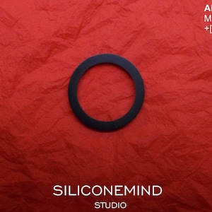 May include: A black ring on a red textured background. The text "AKAI MG1212 +[?...]", "SILICONEMIND STUDIO" is visible on the image.