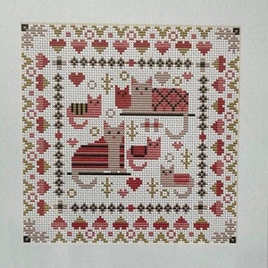 May include: A counted cross stitch kit featuring a design of cats in a cozy setting. The kit includes fabric, thread, needle, chart, and instructions. The finished embroidery will be approximately 6 3/4 inches square.