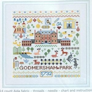 May include: A counted cross stitch kit featuring a colorful illustration of Godmersham Park, a historic house in Kent, England. The kit includes 14 count Aida fabric, threads, a needle, a chart, and instructions. The finished embroidery will be approximately 10 inches square.