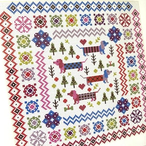 May include: A cross-stitch pattern featuring a square design with a white background. The design includes dachshund dogs, trees, hearts, and geometric patterns in various colors like red, blue, green, and purple. The border is a repeating pattern of red and brown.