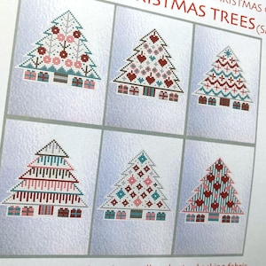 May include: A collection of six small Christmas tree designs, each with a unique pattern. The trees are made with cross-stitch, featuring red, pink, blue, and white colors. The text "CHRISTMAS TREES (SMALL)" is visible at the top.