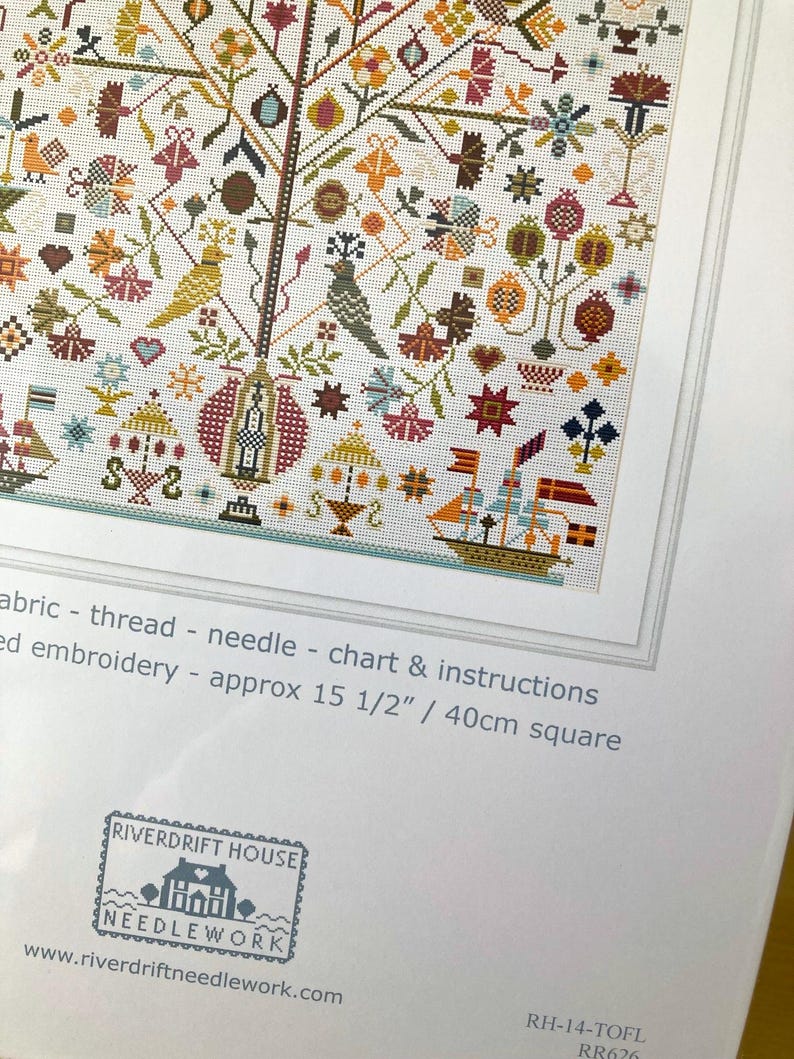 Pu&ograve; includere: Uno sfondo bianco con un motivo a punto croce colorato di un albero con uccelli, fiori e altri disegni. Il testo "Riverdrift House Needlework" e "www.riverdriftneedlework.com" &egrave; stampato sotto l'immagine. Il testo "RH-14-TOFL RR626" &egrave; stampato nell'angolo in basso a destra.