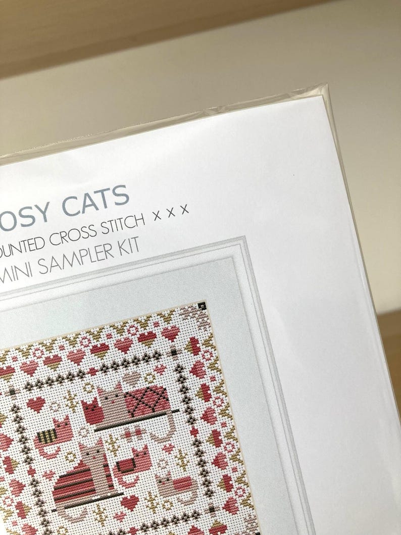May include: A cross stitch kit featuring a design of cats and hearts. The kit is titled "Crafty Cats" and is a mini sampler kit.