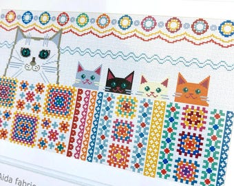 May include: A counted cross stitch kit featuring a design of several cats peeking over a colorful blanket. The kit includes Aida fabric, thread, a needle, and instructions. The finished embroidery size is approximately 16" x 9". The text "NEW BLANKETS" is at the top.