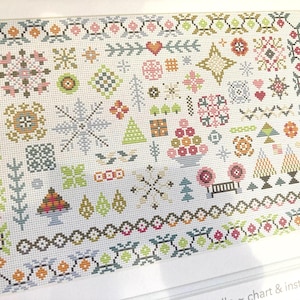 May include: A cross-stitch pattern featuring a variety of geometric and floral designs in pastel colors. The design includes snowflakes, hearts, trees, and other decorative elements, framed by a patterned border.