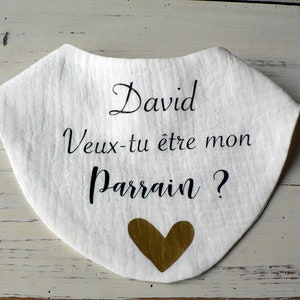 May include: White fabric bib with black text that reads "David Veux-tu &ecirc;tre mon Parrain?" with a gold heart.