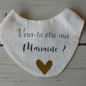 May include: White fabric bib with black text that reads "Veux-tu &ecirc;tre ma marraine?" and a gold heart.