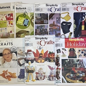 May include: A selection of sewing pattern envelopes from brands such as Butterick, Simplicity, and McCall's. The patterns are for crafts and holiday projects. The envelopes show images of the finished items, offering design inspiration.