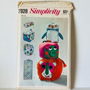 May include: A vintage Simplicity sewing pattern, number 7928, showcasing designs for soft toy animals. The pattern includes instructions for making a pig, penguin, lion, and other creatures. The pattern is marked "One Size" and priced at 65¢.