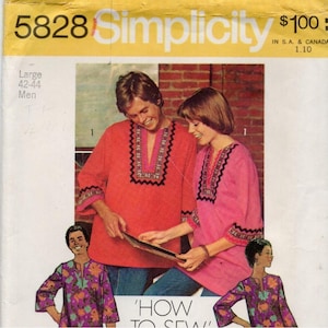 May include: A Simplicity 5828 sewing pattern envelope featuring a large size 42-44 shirt design. The cover displays two individuals wearing long-sleeved tunics with decorative trim around the neckline and cuffs, one in red and one in pink.