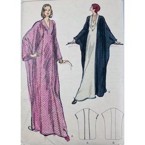 May include: A sewing pattern illustration featuring two floor-length kaftan-style garments. Version A is pink with black polka dots and a V-neckline. Version B is a solid dark blue outer layer over a white inner layer with a long necklace.