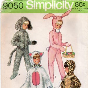 May include: A vintage Simplicity 9050 sewing pattern envelope featuring illustrations of children in animal costumes. The designs include a grey curly-textured dog, a pink bunny with long ears, a white cat with pink accents, and a tiger-striped suit.