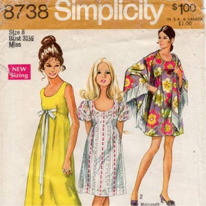 Op de afbeelding: Een Simplicity naaipatroon envelop 8738 voor maat 8, buste 80 cm. De hoes bevat illustraties van drie jurken: een vloerlange gele mouwloze jurk met een witte strik, een witte jurk met bloemenprint en pofmouwen, en een bloemrijke poncho.