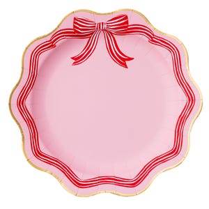 May include: A pink paper plate with a scalloped edge and a gold rim. The plate features a red and white striped bow at the top and a red and white striped border. This decorative plate is perfect for a party or special occasion.