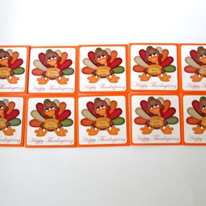 May include: A collection of ten Thanksgiving-themed square cards. Each card features a cartoon turkey with colorful feathers and the text "Happy Thanksgiving". The cards have an orange border and a white background.