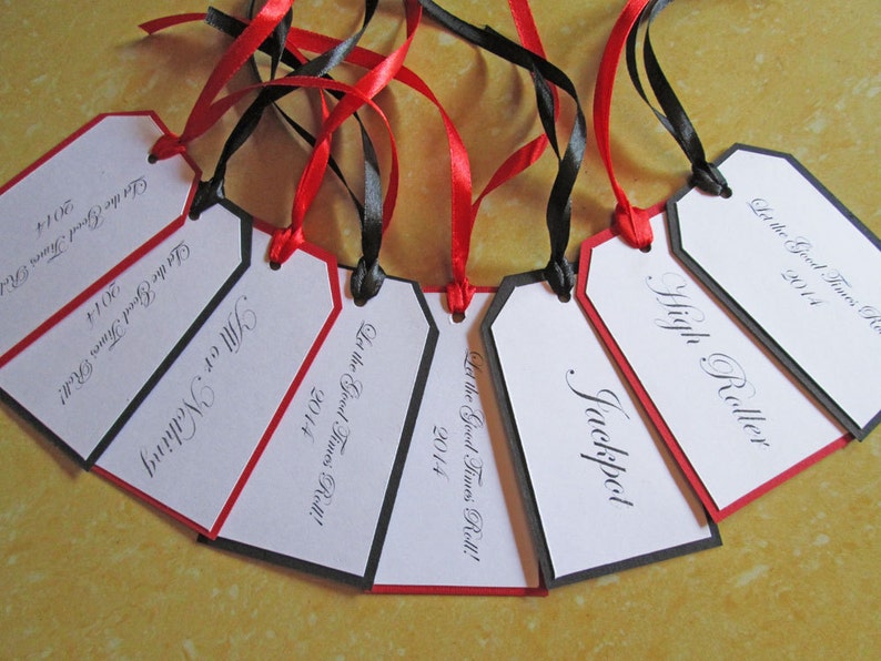 May include: A set of six white gift tags with black and red trim. Each tag has a different name written in black cursive script. The text "Let the Good Times Roll!" and the year "2014" are printed on each tag.