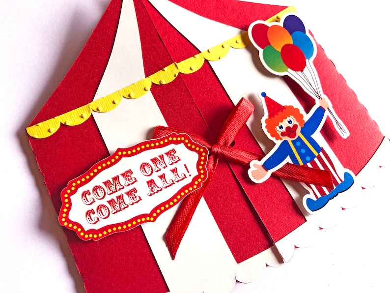 Puede incluir: Una invitaci&oacute;n de circo en forma de carpa roja y blanca con un borde festoneado amarillo. Una cinta roja est&aacute; atada alrededor de la carpa con un cartel blanco que dice "&iexcl;Venid todos!" Un payaso con el pelo rojo y una camisa a rayas azul y blanca sostiene un ramo de globos de colores.