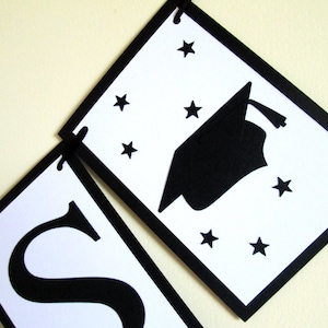 May include: Black and white graduation banner with the word "Class" and a graduation cap with stars.