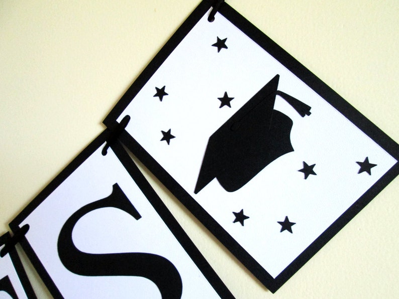 May include: Black and white graduation banner with the word "Class" and a graduation cap with stars.