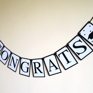 May include: Black and white graduation banner with the word "CONGRATS" and a graduation cap icon.